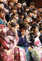 يخلع المشاركون أقنعة الوجه لالتقاط صور تذكارية خلال احتفال بلوغ سن الرشد في ناميه بمحافظة فوكوشيما اليابانية. ا ف ب