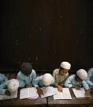 طلاب يقرأون القرآن الكريم في أحد الفصول الدراسية خلال شهر رمضان بمدرسة في حيدر أباد بالهند. (ا ف ب)