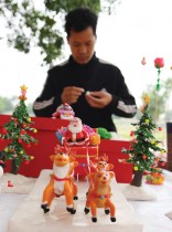 رجل يصنع تماثيل عيد الميلاد خلال مهرجان الزهور في منطقة مي لينه بضاحية هانوي  - ا ف ب