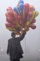 بائع بالونات يسير في شارع وسط ضباب كثيف في صباح شتوي بارد في امريتسار ،الهند. ا ف ب