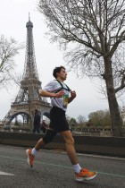 عداء يتنافس خلال النسخة 46 من ماراثون باريس، 42195 كيلومترًا ، ويبدو برج إيفل في الخلفية.  ا ف ب