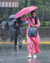 هنود يشقون طريقهم عبر شارع وسط هطول أمطار غزيرة في مومباي - ا ف ب