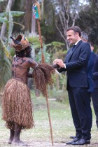الرئيس الفرنسي يصافح راقصة بالزي التقليدي خلال حفل تقليدي على شرفه في توهو شمال كاليدونيا الجديدة  - ا ف ب