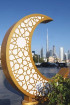 يظهر برج خليفة في دبي وهو أطول مبنى في العالم خلف زخرفة احتفالية على شكل هلال أقيمت لشهر رمضان المبارك «ا ف ب» 