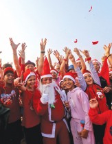 أشخاص يرتدون قبعات بابا نويل يشاركون في جلسة يوغا ضحك خلال احتفالات عيد الميلاد على شاطئ في مومباي، الهند. رويترز