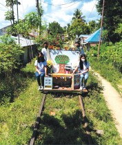 متطوعون من الطلاب يركبون عربتهم المؤقتة التي تعمل كمكتبة متنقلة للأطفال، في تاغكاوايان، الفلبين. رويترز