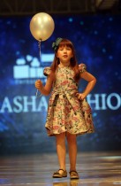 طفلة تعرض ابتكارا للمصممة العمانية داليا بسامي خلال إطلاق النسخة السابعة من عرض أزياء  Ladies a La Mode ، في العاصمة العمانية مسقط.   أ ف ب