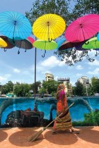 عاملة تسير تحت تركيب فني للمظلات الملونة بينما خففت الحكومة القيود وسط جائحة فيروس كورونا في مومباي.ا ف ب