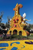 عاملة تضع اللمسات الأخيرة على تمثال مصنوع من الليمون والبرتقال يُدعى «زواج فيجارو» خلال مهرجان الليمون الثامن والثمانين حول موضوع «الأوبرا والرقصات»  في مينتون ، فرنسا.   رويترز