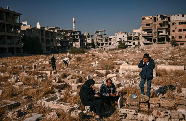 فلسطينيون يزورون مقابر أحبائهم في مخيم اليرموك 