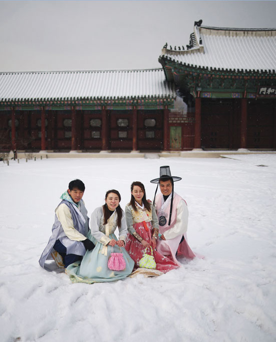 سائحون يرتدون الزي التقليدي الكوري «الهانبوك» يلتقطون الصور أثناء تساقط الثلوج في يوم شتوي بارد في قصر جيونج بوكجونج في سيول. رويترز