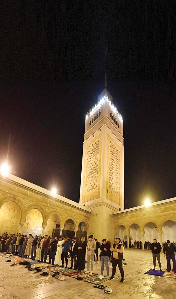 مصلون يؤدون صلاة «التراويح» في باحة مسجد الزيتونة التاريخي بالعاصمة التونسية. (ا ف ب)