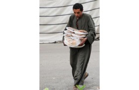 رجل يحمل وجبات ساخنة وزعها متطوعون على الصائمين خلال شهر رمضان المبارك في القاهرة، مصر (رويترز)