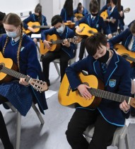 طلاب يرتدون أقنعة واقية للوجه أثناء مشاركتهم في درس موسيقي في اليوم الأول من العودة إلى المدرسة، جنوب لندن. رويترز