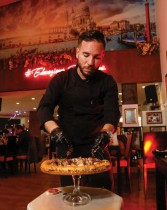 أحمد هرجال ، مؤسس المطعم الإيطالي L'antica Pizzeria DaPietro ، يضيف مكونات إلى بيتزا 999 دينارًا 360 دولارًا أمريكيًا