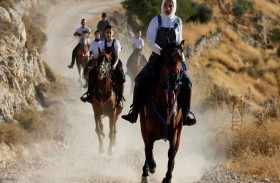 فارسة فلسطينية تعلم الأطفال ركوب الخيل