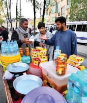 عملاء يشترون بعض مستلزمات تناول الإفطار في أحد الأسواق خلال شهر رمضان المبارك في كابول. ا ف ب 