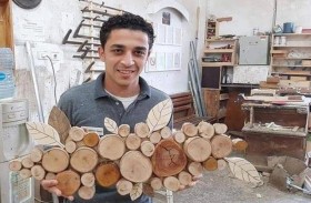 يصنع التحف الخشبية بأيدي مبتورة الأصابع