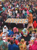 متطوعون يوزعون طعامًا مجانيًا بينما يتجمع المصلون المسلمون لتناول الإفطار خلال شهر رمضان المبارك في لاهور الباكستانية. (ا ف ب)